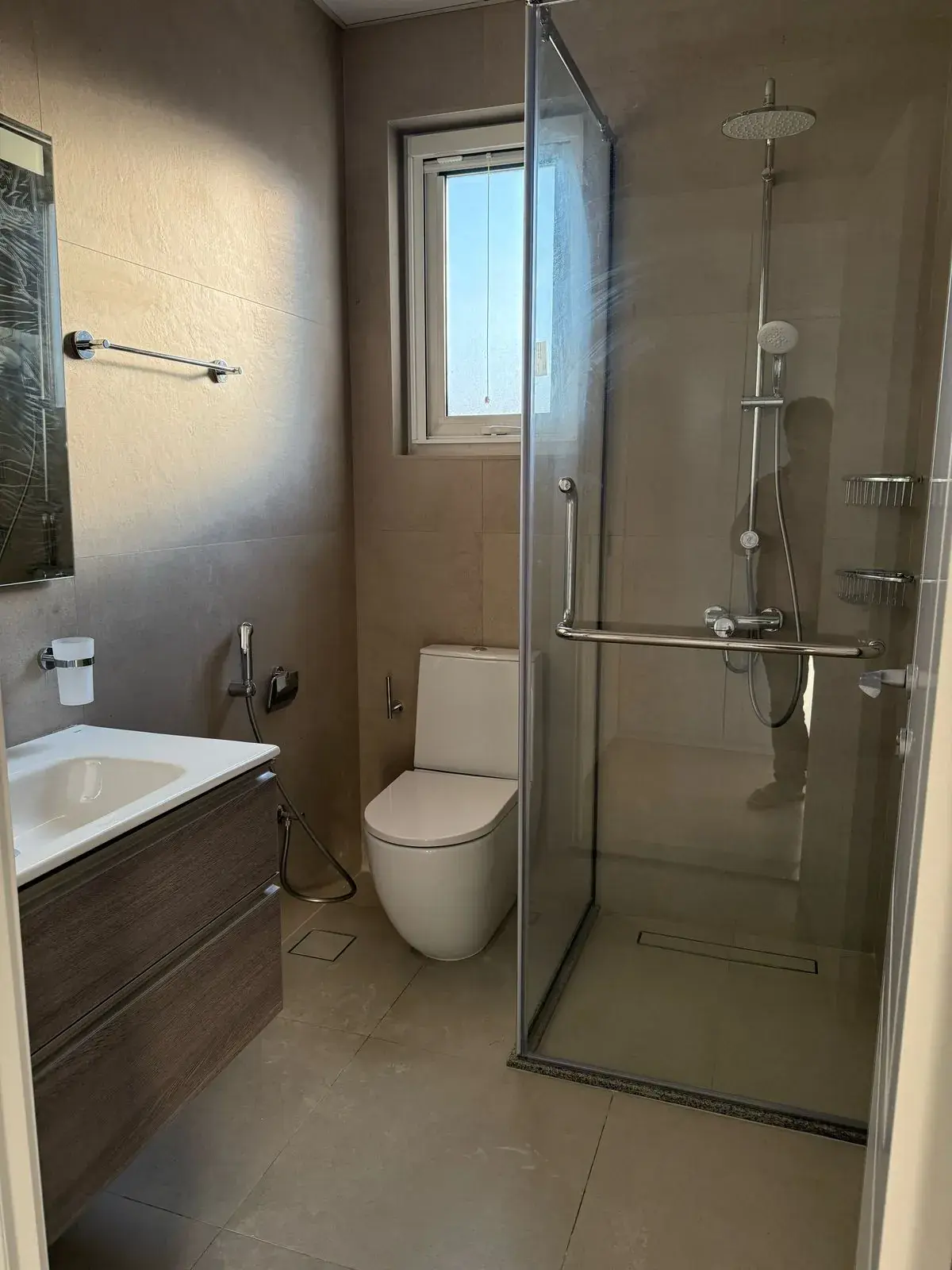 Renovated bathroom with glass shower enclosure and wall-hung toilet